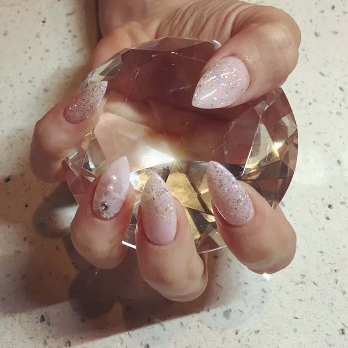 A finished manicure with soft pink polish and neat cuticles