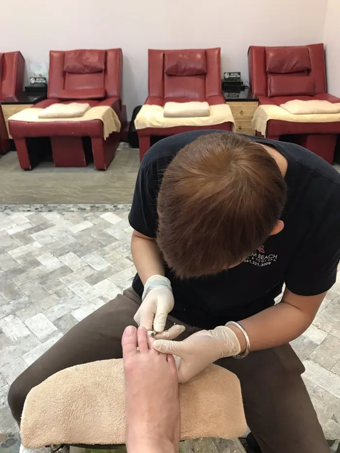 A technician giving a pedicure while a guest rests in a massage recliner